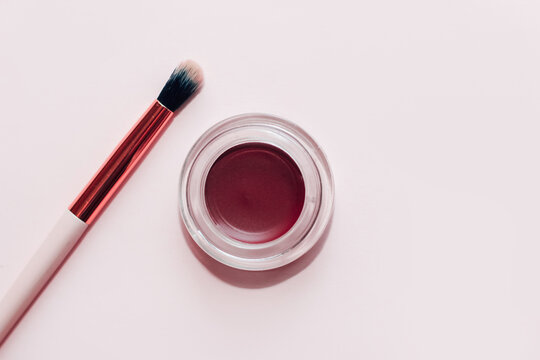 A Jar With Eyeshadow And Eyebrow Pomade On A White Background.