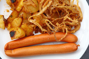 Close up portion of sausages with roasted potato