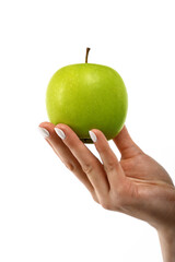 Woman hand holds green apple over white