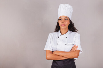 young black brazilian woman, cook, masterchef. With arms crossed.