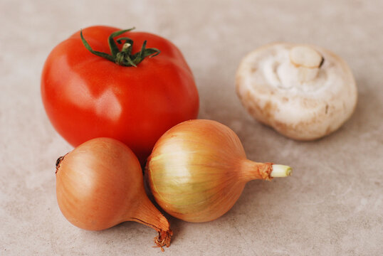 Świeże, dojrzałe warzywa i owoce na stole, pomidor, cebule i pieczarka, gotowanie z naturalnych produkt&oacute;w, zdrowa dieta dla wegan i wegetarian