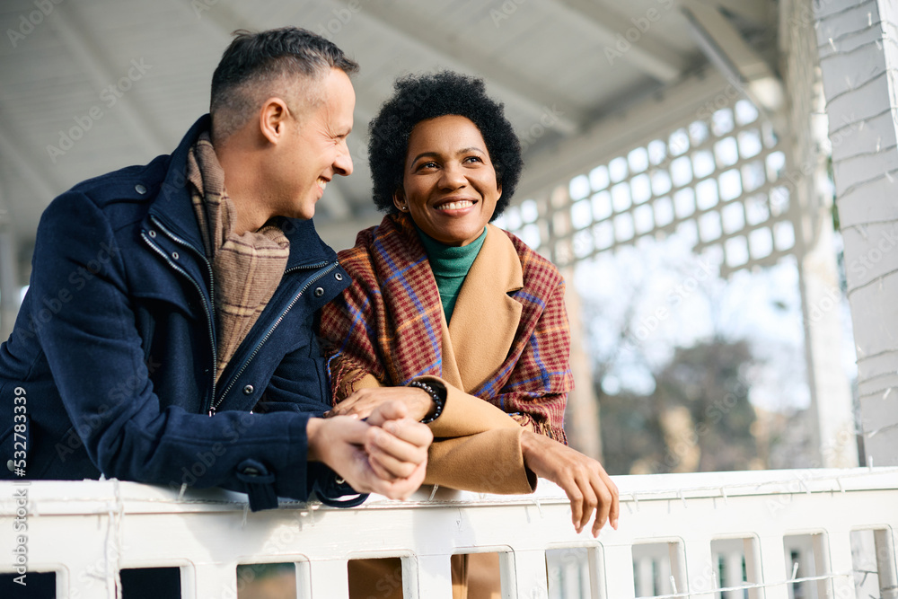 Wall mural Happy black woman and her husband enjoy in gazebo at park during winter season.