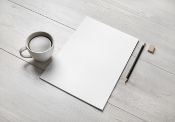 Blank white letterhead, coffee cup, pen and eraser.