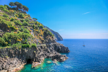 Cinque Terre idyllic coastline cliffs and lonely sailboat, Liguria, Italy