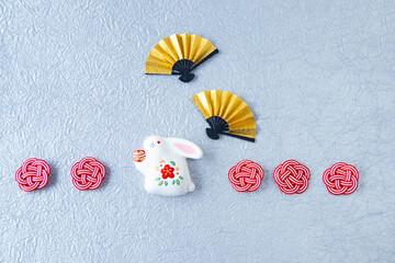日本の正月イメージ　卯年の兎と金色の扇と紅白の水引と銀色の和紙（銀色の背景）