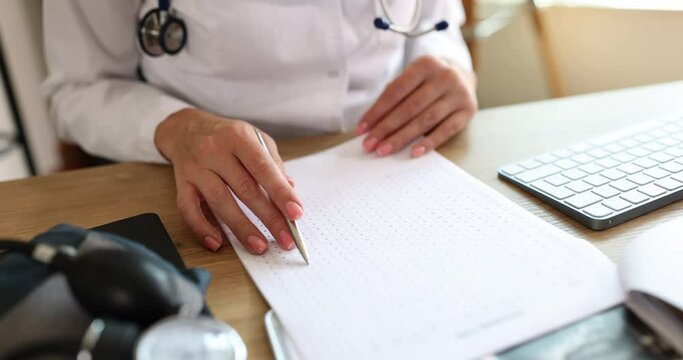 Doctor hands pointing at patient electrocardiogram chart