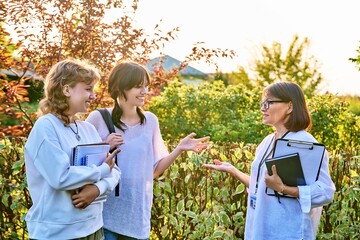 Female teacher talking to teenage female students outdoor