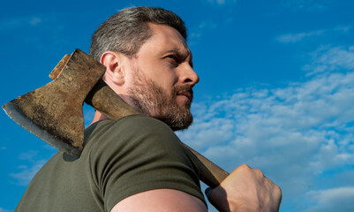 man with axe. brutally man hold ax. brutal man on sky background