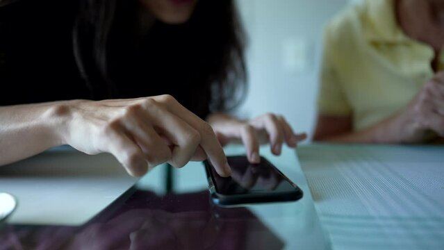 Closeup hands touching smartphone screen. Woman using phone touches screen browsing social media internet