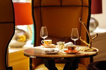 Luxury restaurant marble table dining setup with ceramic tea pots, wine glasses and premium dine accessories. Fine restaurants food industry.
