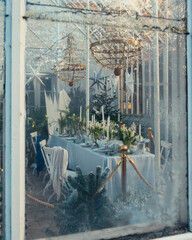 A table set with winter and christmas decor placed in a garden house
