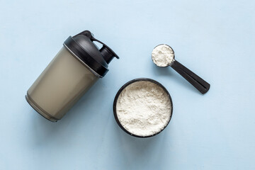 Whey protein powder in jar with shaker for mixing. Fitness and gym diet