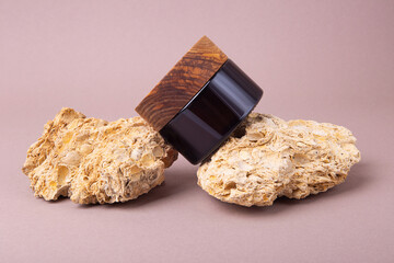 Eco friendly cream container with wooden cover on the natural stones.Good as cosmetics mockup.