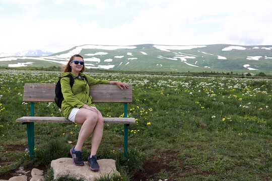 Woman sitting on bench on Lago-Naki plateau
