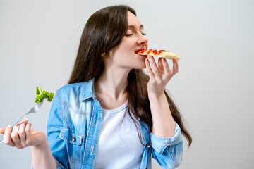 Young beautiful woman breaks the diet, but happy eats pizza instead of salad