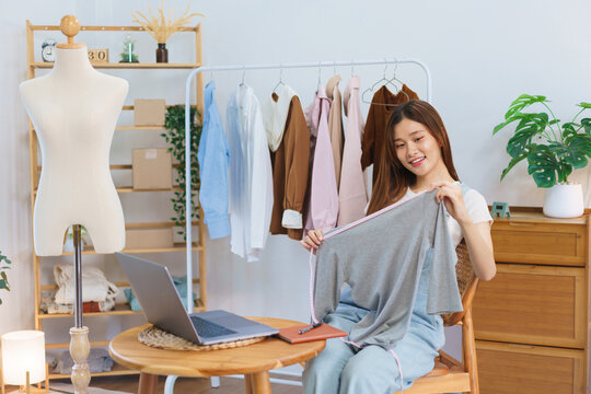 Online shopping concept, Young Asian women is selling and present clothes detail on video streaming