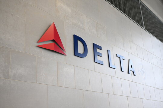 Delta Airlines sign with logo on a grey wall. Detroit, MI airport in December 2021. Delta is member of the Skyteam alliance