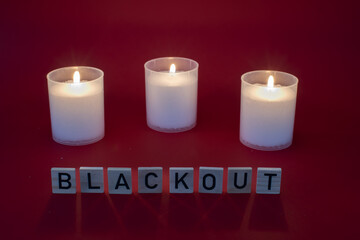 Kerze während eines Stromausfall mit dem Wort Blackout als Text