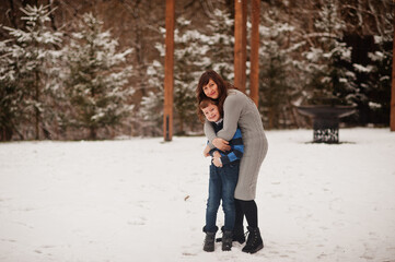 Mother hug son in winter day, spending time together.