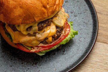juicy burger with two meat patties and fresh vegetables