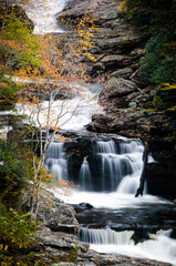Cullasaja Falls waterfall surrounded by a beautiful and colorful autumn forest in North Carolina. 