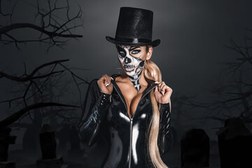 Woman in Halloween silence. Sexy woman in top hat and skull make up. Halloween makeup and costume...