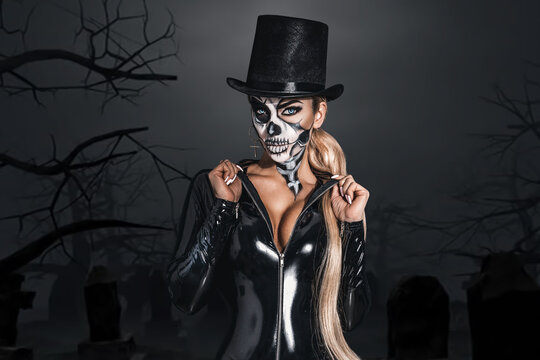 Woman in Halloween silence. Sexy woman in top hat and skull make up. Halloween makeup and costume concept.