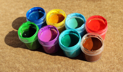 Acrylic paints in jars. Photo of opened pots with different colors of paint 