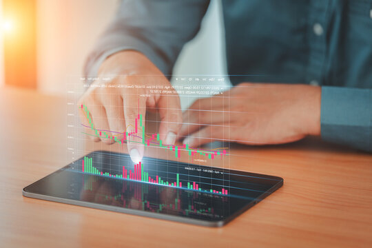 investor using tablet showing virtual hologram of analysis virtual stock market chart , planning and strategic concepts.