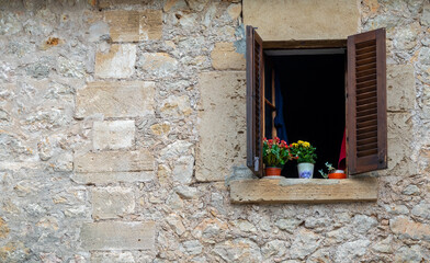 Fototapeta na wymiar window with wooden shutters and flowers pots