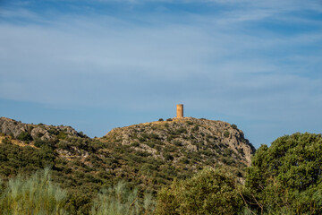 Atalaya de Deifontes (Spain) on a rocky hill surrounded by oaks on a sunny summer morning