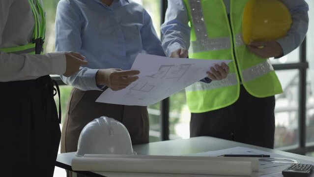 construction meeting construction with builders Architects and Engineers and inspector They were looking at the various planning blueprints in the office. 4K stock video clip.