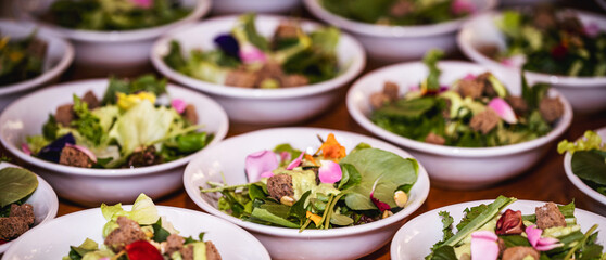 vegetable salad, vegetables and flowers. multiple salad bowls with arugula, flower petals, vegan toast