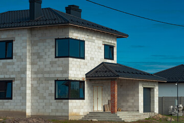 Building site of a house under construction made from white foam concrete blocks. Building new frame of home.