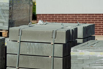 Blocks of building tiles of gray color are on the street. Theme of building construction.