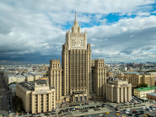 Moscow cityscape within day time. Offices buildings exterior. Building of the Ministry of Foreign Affairs  MFA. Rooftops of residential houses on blue sky, bottom up view coat of arms of the USSR