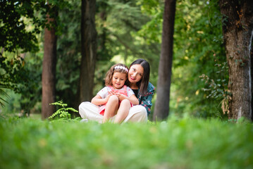 Fototapeta premium mother and daughter sitting in the park hugging each other