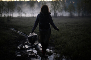 Girl walks in fog in morning. Rest in wild. Fog in swamp.