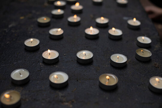 Lots of round candles on grave. Details of memorial ceremony. Candles made of wax.