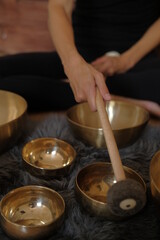 Women using singing copper bowl. Yoga, relaxation and meditation. Sound therapy, alternative medicine