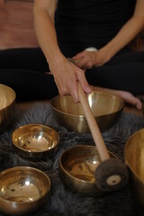 Women using singing copper bowl. Yoga, relaxation and meditation. Sound therapy, alternative medicine