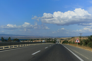 Naklejka premium Highway wide road, transport and blue sky with clouds on a summer day