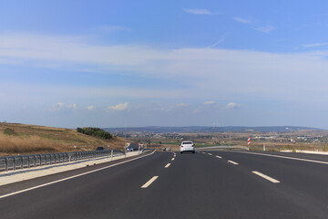 Fototapeta premium Highway wide road, transport and blue sky with clouds on a summer day