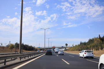 Fototapeta na wymiar Highway wide road, transport and blue sky with clouds on a summer day