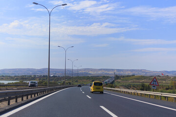Fototapeta premium Highway wide road, transport and blue sky with clouds on a summer day