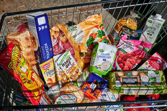 Berlin, Germany - September 1, 2022: View into a full shopping cart with various products for daily needs.