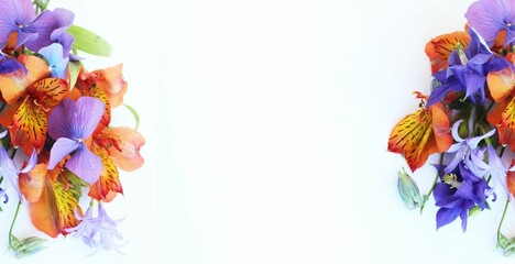 A magnificent bouquet of lilac irises and orange alstroemeria on a light background. Background for a greeting card.