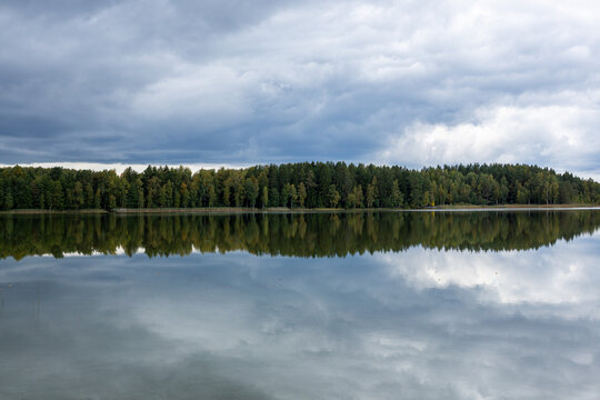 Peaceful scenery of lake Katvari on a cloudy day in September with cloud reflections in water in Latvia