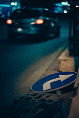 Fototapeta znak drogowy leżący na ziemi samochód ulica noc obraz