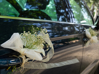Wedding decoration with flowers on the white car